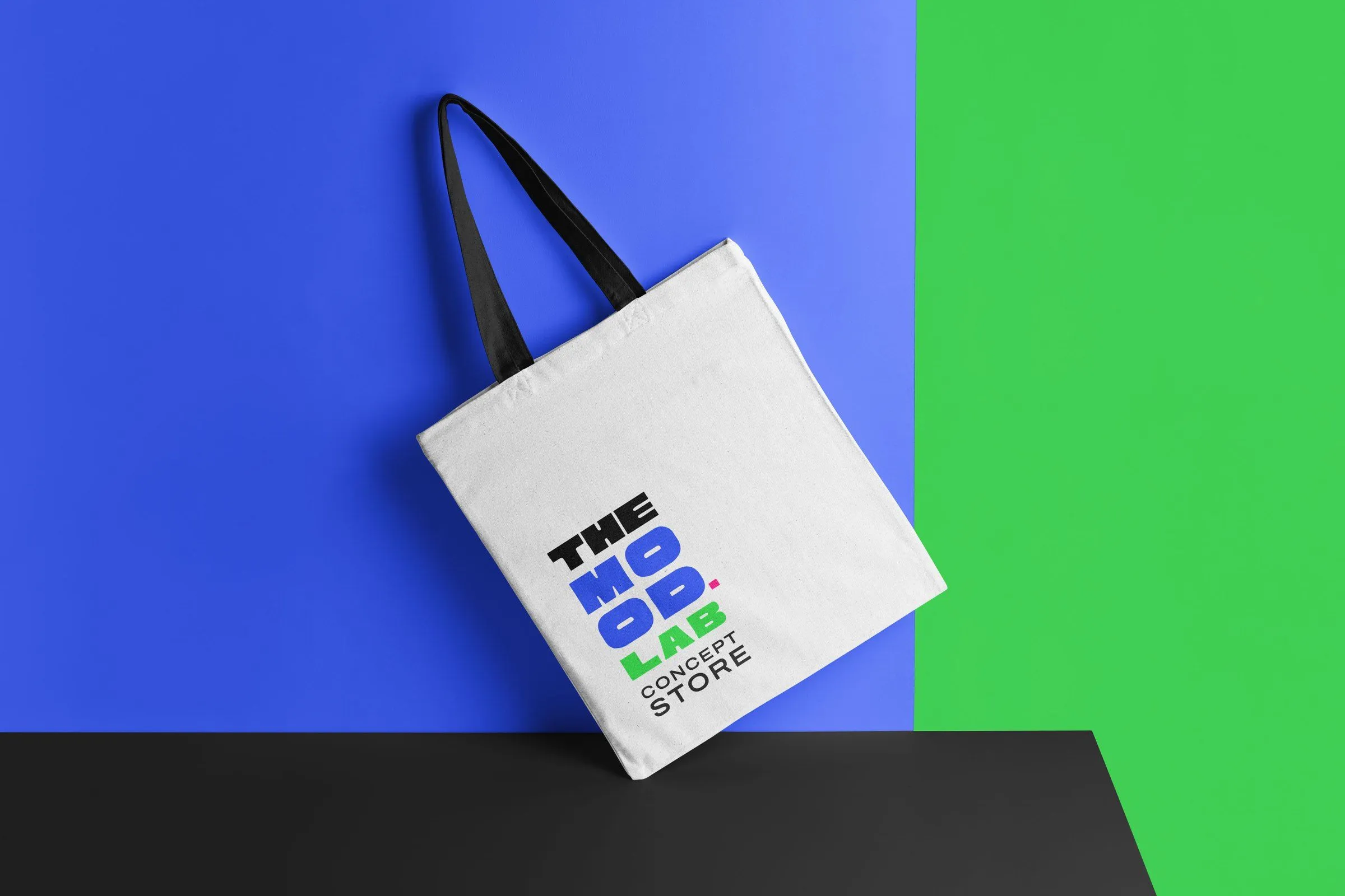 Tote bag blanca con el logo de The Mood Lab sobre fondo azul y verde